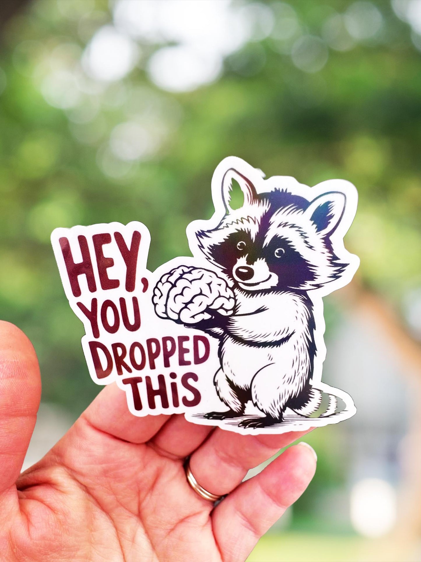 Hey you dropped this sticker- raccoon holding brain