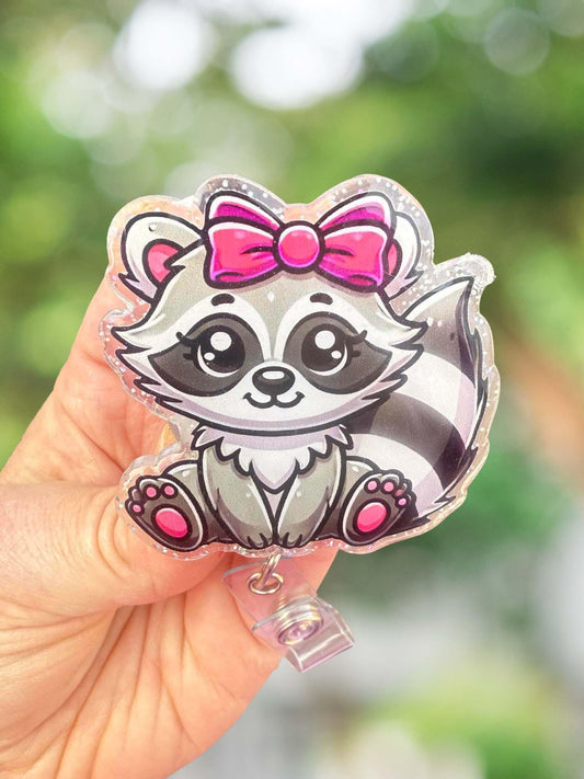 Raccoon with pink bow badge reel